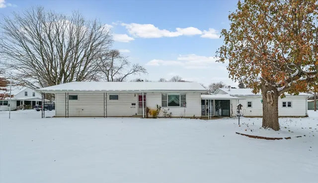 a view of a white house with a large tree