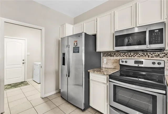 a kitchen with cabinets and steel stainless steel appliances