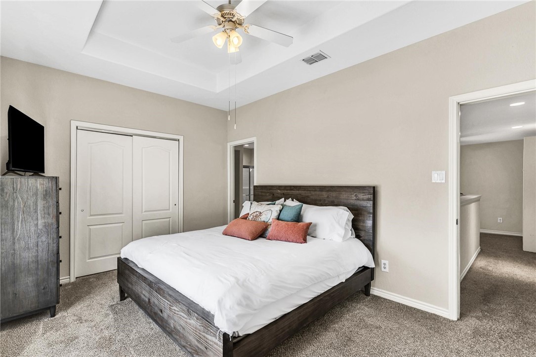 15417 Gun Cay Court, Unit B Corpus Christi, TX 78418 - Photo 21 of 35 a bedroom with a bed and a chandelier