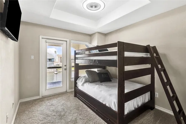 a bedroom with a bed and a flat tv screen on the dresser