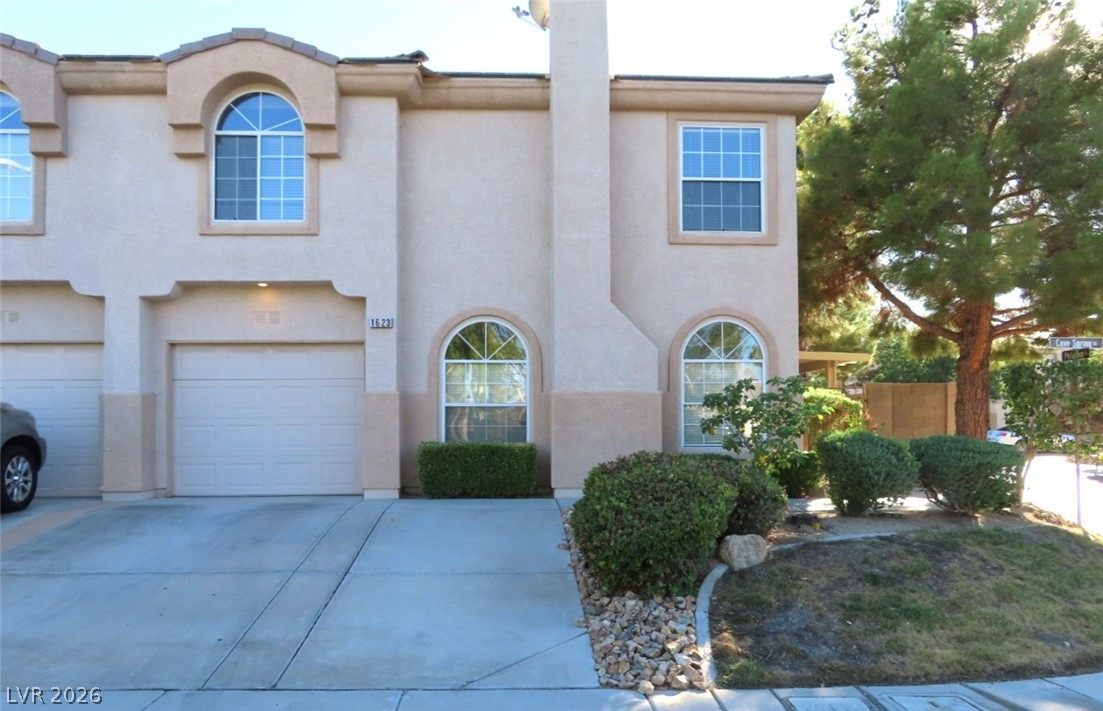 1623 Cave Spring Drive Henderson, NV 89014 - Photo 3 of 16 Elegant arched windows enhance the stucco facade of this welcoming townhome with an attached garage.