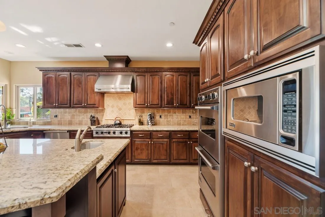 1070 Heritage Ranch Road Ramona, CA 92065 - Photo 27 of 73 a kitchen with granite countertop stainless steel appliances and wooden cabinets