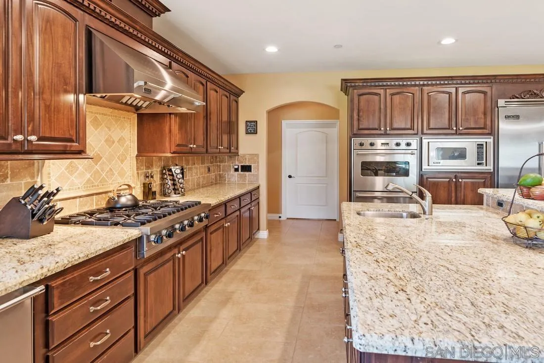 1070 Heritage Ranch Road Ramona, CA 92065 - Photo 29 of 73 a kitchen with stainless steel appliances granite countertop a stove a sink and a refrigerator