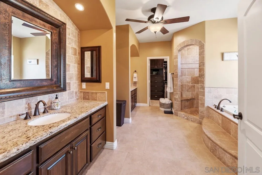 1070 Heritage Ranch Road Ramona, CA 92065 - Photo 33 of 73 a spacious bathroom with a granite countertop sink a large mirror and a bathtub
