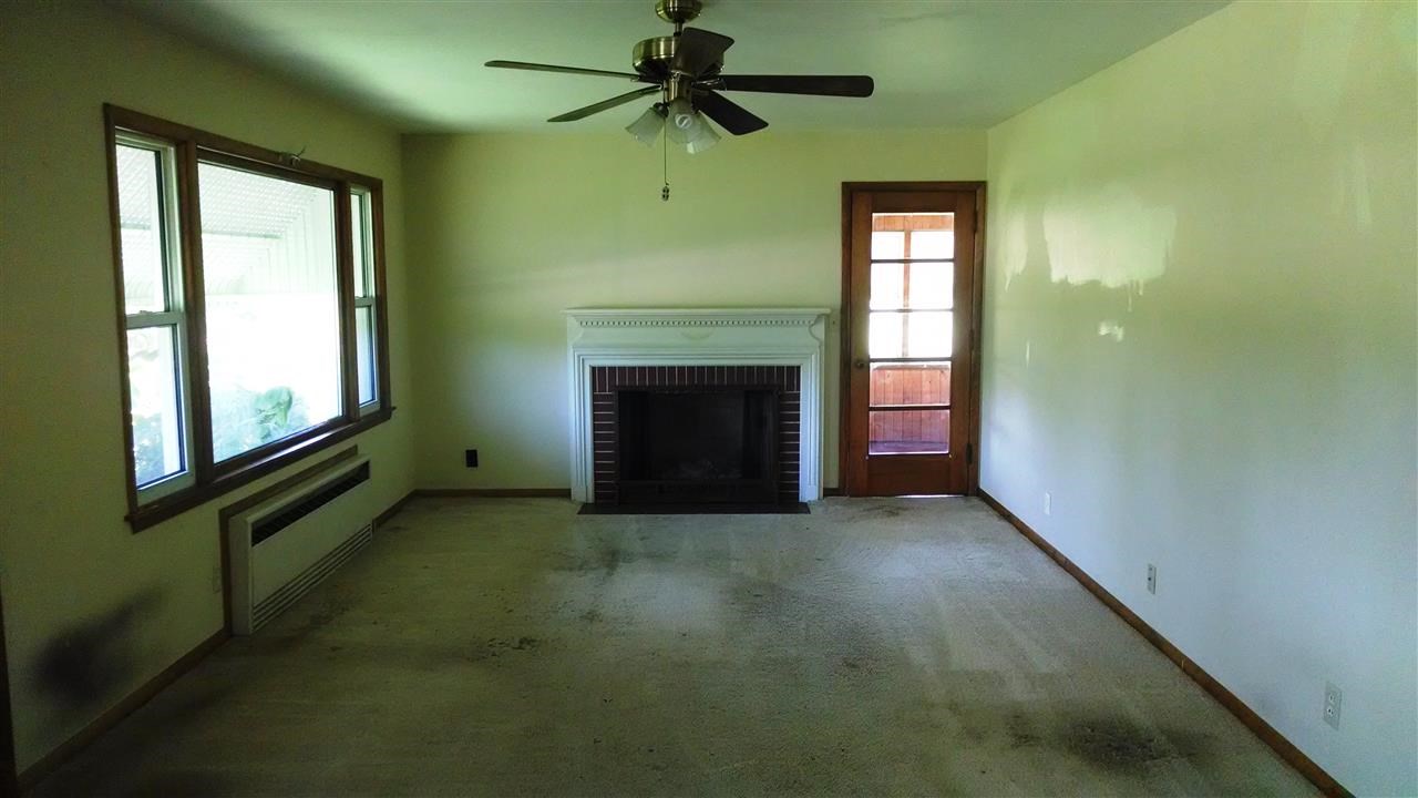 3219 Prairie Road Rockford, IL 61102 - Photo 2 of 12 a view of an empty room with chandelier fan and fire place