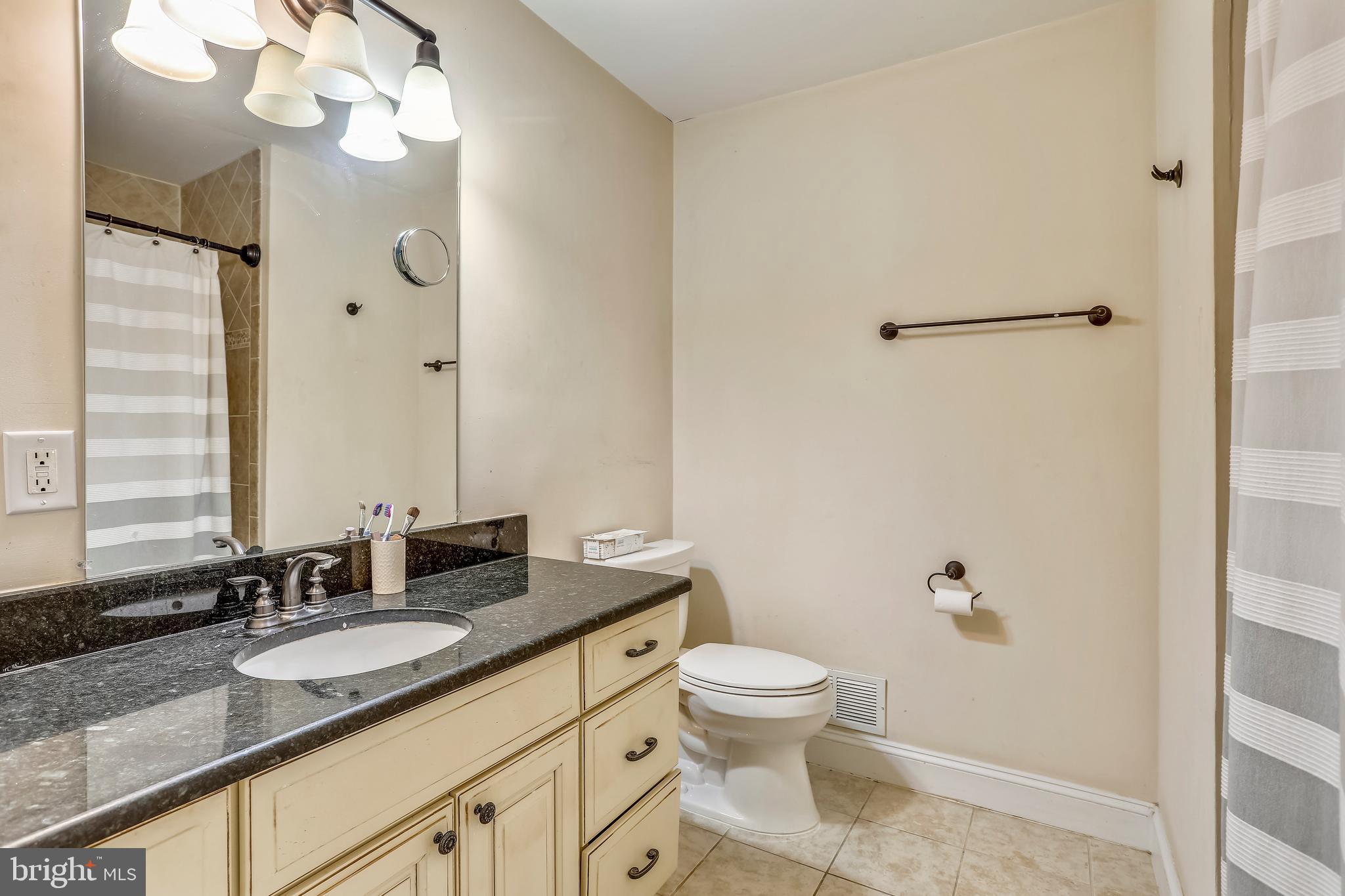 10145 Colebrook Avenue Potomac, MD 20854 - Photo 12 of 30 a bathroom with a granite countertop sink mirror vanity and toilet