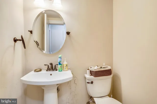 a bathroom with a toilet sink and mirror