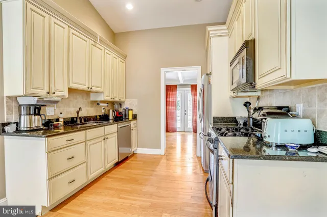 a kitchen with stainless steel appliances granite countertop a stove a sink and a white cabinets