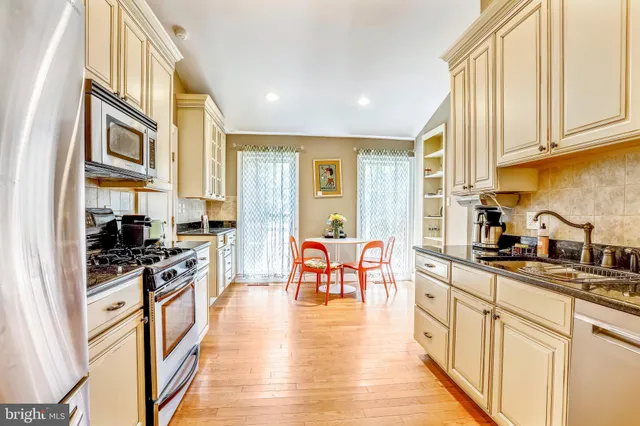 a kitchen with stainless steel appliances granite countertop lots of counter top space and wooden floor