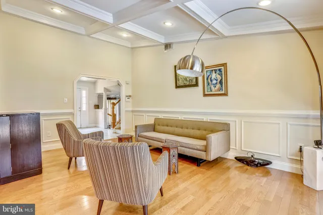 a living room with furniture a flat screen tv and a table