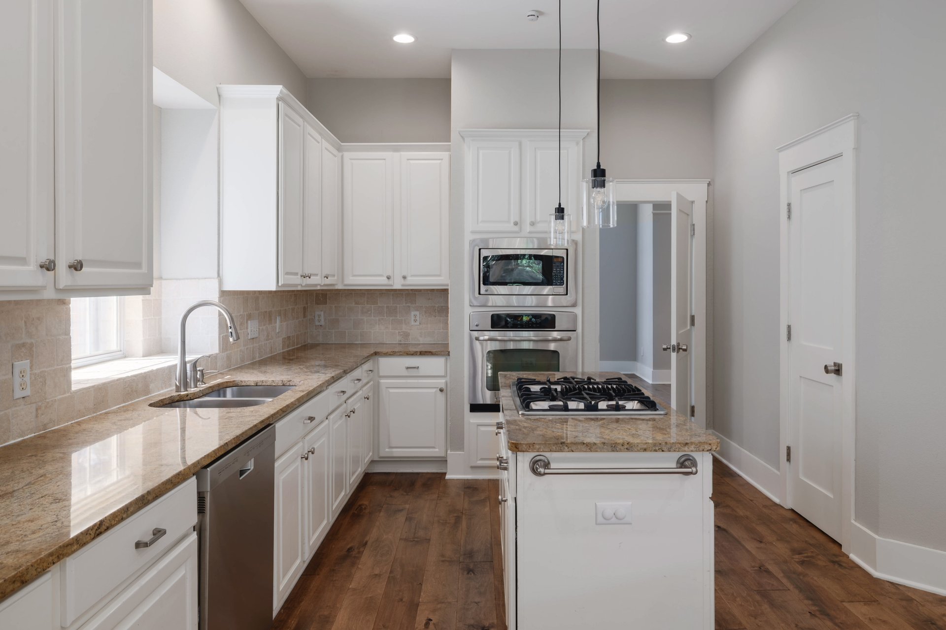 5512 Ballenton Lane Austin, TX 78739 - Photo 15 of 40 Culinary aspirations find a home in this well-appointed kitchen featuring rich wood floors and stone countertops.