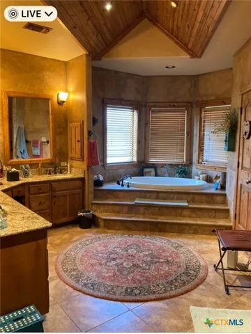 a bathroom with a tub sink and mirror