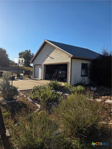a front view of house with yard and trees in the background