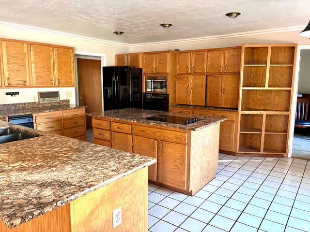 1903 Ridgehollow Drive Bountiful, UT 84010 - Photo 7 of 24 Kitchen featuring extensive wood cabinetry, granite-finish countertops, a central island with an integrated cooktop, and white square floor tiling