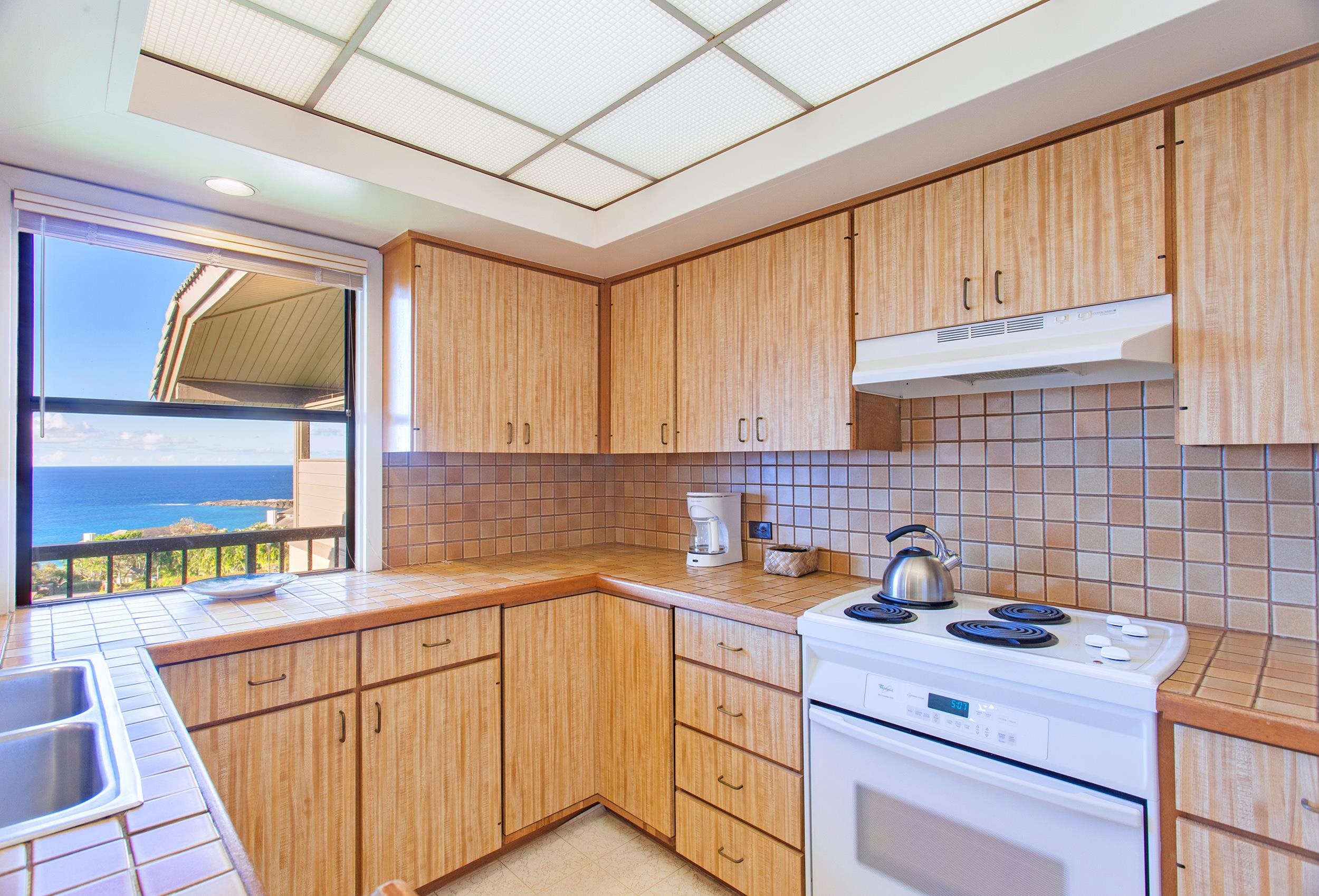 100 Ridge Road, Unit 321 Lahaina, HI 96761 - Photo 8 of 30 a kitchen with a sink a stove cabinets and a window