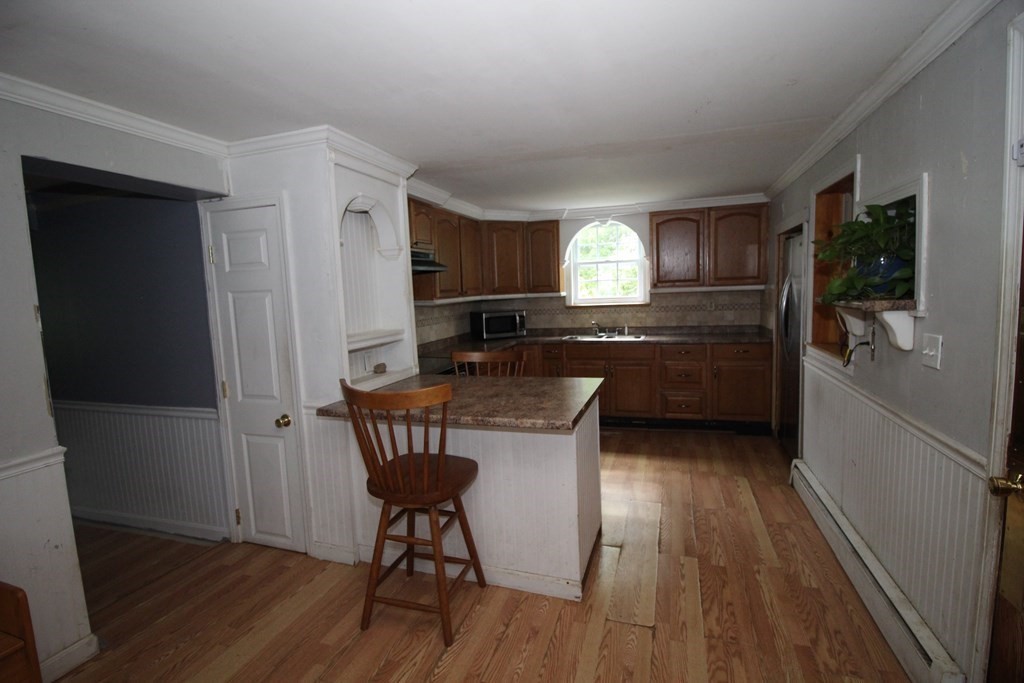 91 Davis Road Westminster, MA 01473 - Photo 17 of 37 a kitchen with granite countertop a sink cabinets and wooden floor