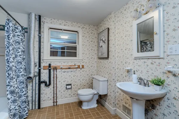 a bathroom with a toilet sink and mirror