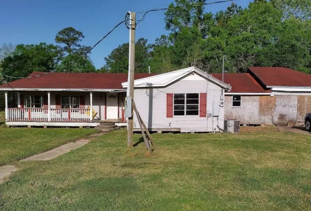 a front view of a house with a garden and trees