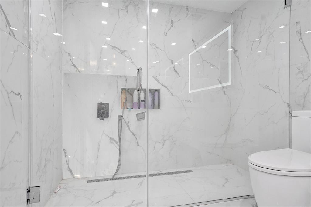 2801 Northeast 183rd Street, Unit 101W Aventura, FL 33160 - Photo 15 of 39 a bathroom with a shower and toilet