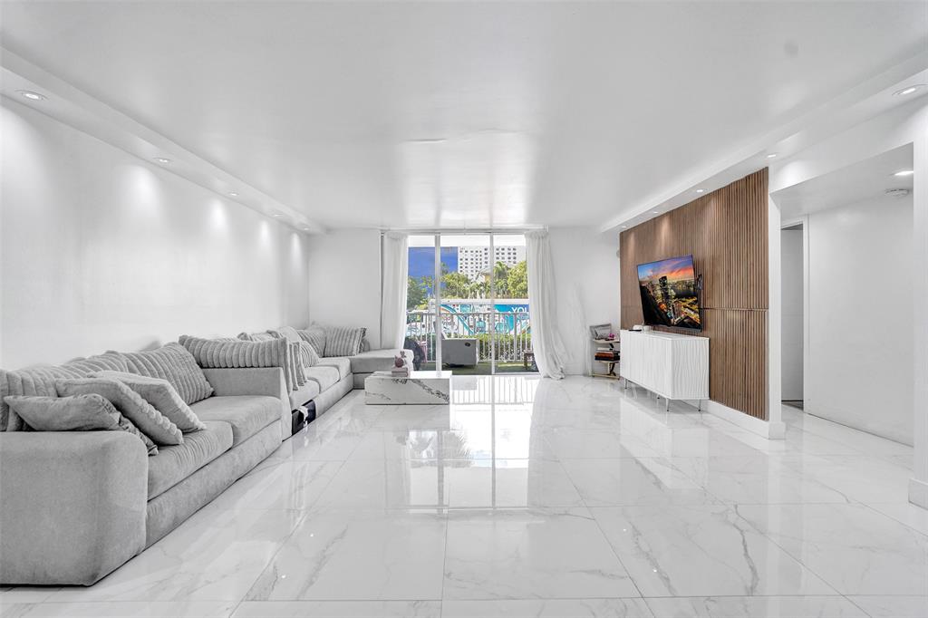 2801 Northeast 183rd Street, Unit 101W Aventura, FL 33160 - Photo 25 of 39 a living room with furniture and a flat screen tv