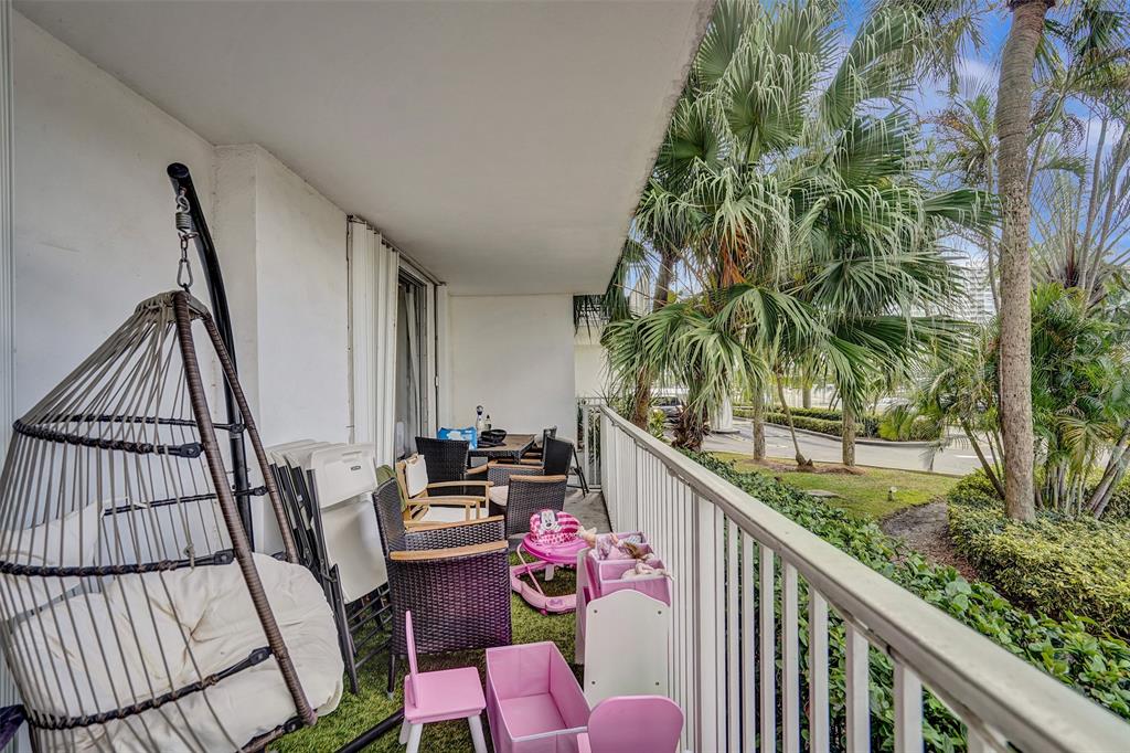 2801 Northeast 183rd Street, Unit 101W Aventura, FL 33160 - Photo 33 of 39 a balcony with wooden floor and furniture
