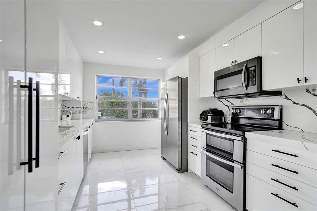 2801 Northeast 183rd Street, Unit 101W Aventura, FL 33160 - Photo 4 of 39 a kitchen with stainless steel appliances a refrigerator sink and microwave