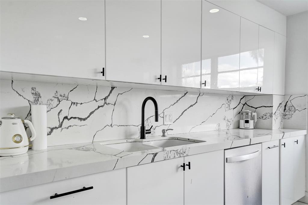 2801 Northeast 183rd Street, Unit 101W Aventura, FL 33160 - Photo 5 of 39 a kitchen with stainless steel appliances a sink a window and cabinets