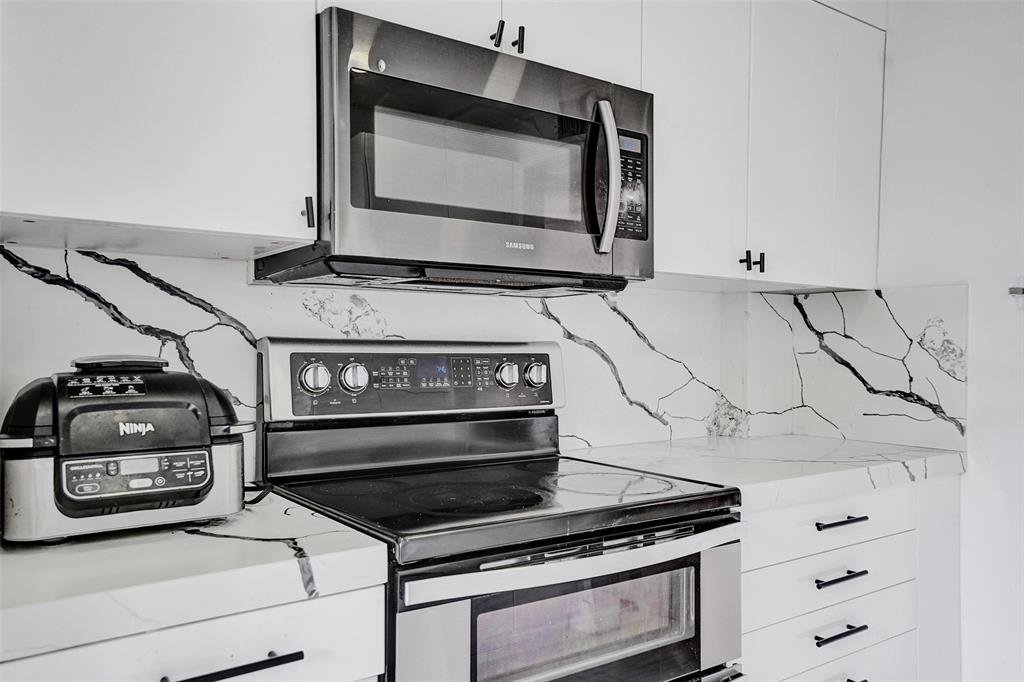 2801 Northeast 183rd Street, Unit 101W Aventura, FL 33160 - Photo 6 of 39 a kitchen with a stove and a microwave