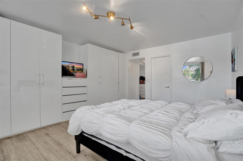 2801 Northeast 183rd Street, Unit 101W Aventura, FL 33160 - Photo 10 of 39 a bedroom with a bed and a chandelier