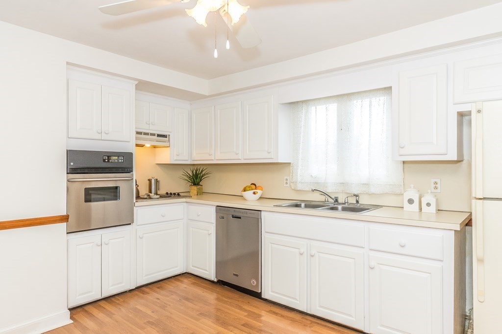 373 Andover Road Billerica, MA 01821 - Photo 10 of 23 a kitchen with a sink white cabinets and white appliances