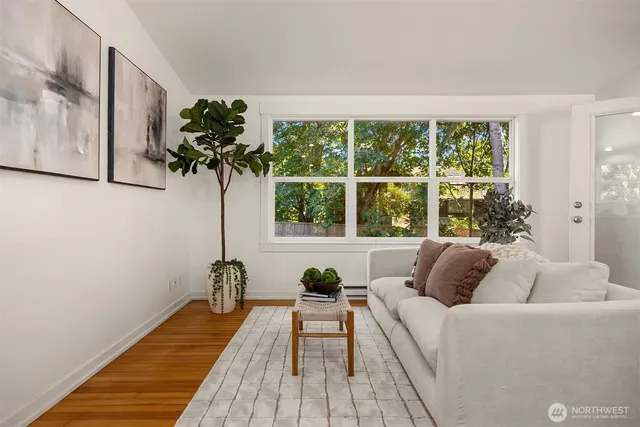 a living room with furniture and a large window with wooden floor