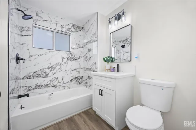 a bathroom with a bathtub sink vanity mirror and toilet