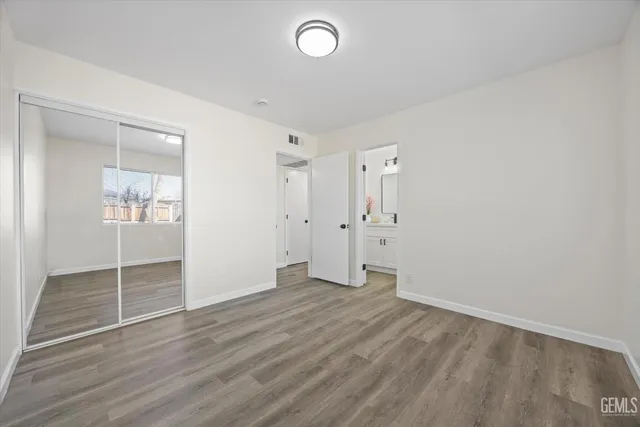 an empty room with wooden floor and mirror