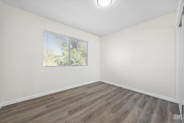 an empty room with wooden floor and window