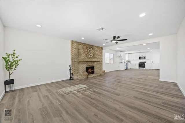 an empty room with wooden floor and fireplace