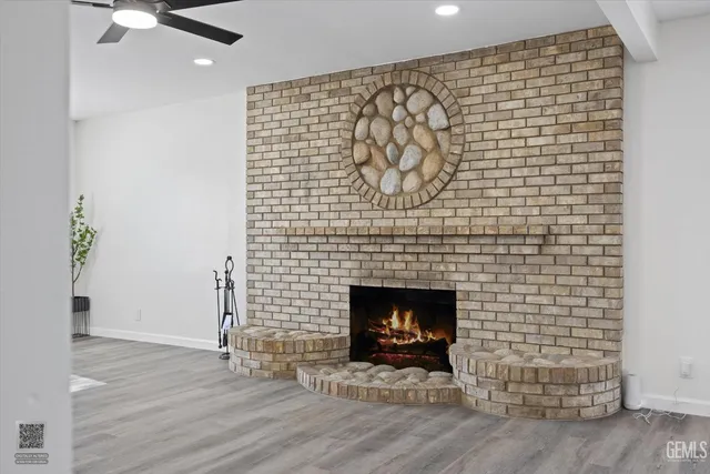 a view of a livingroom with wooden floor and a fireplace