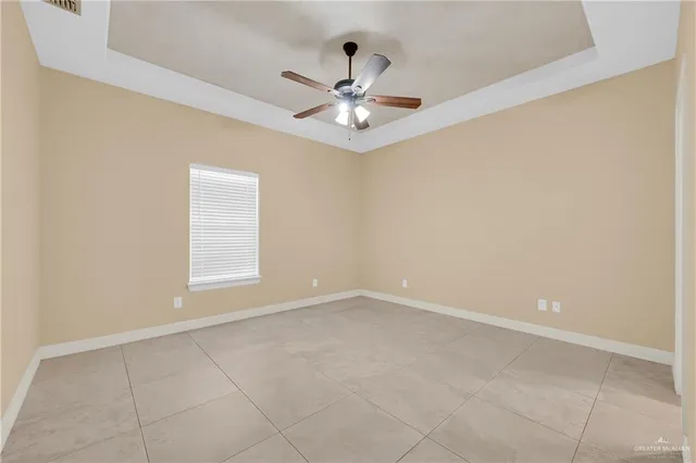 an empty room with window and ceiling fan