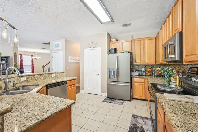 a kitchen with stainless steel appliances granite countertop a refrigerator stove and sink