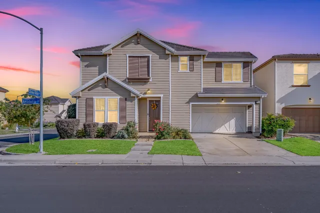 a front view of a house with a yard and garage