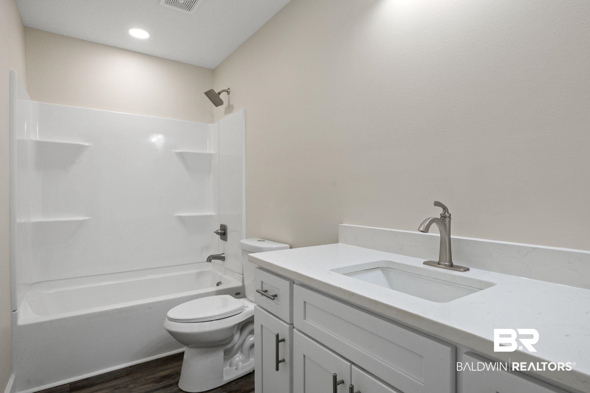 1473 Pollard Road Daphne, AL 36526 - Photo 27 of 32 Full bathroom featuring vanity, tub / shower combination, wood-type flooring, and toilet