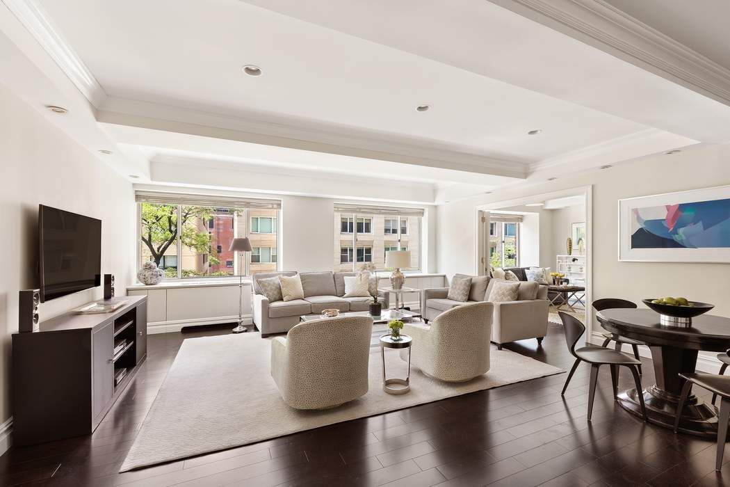 201 East 80th Street, Unit 3D Manhattan, NY 10075 - Photo 3 of 16 a living room with furniture and a flat screen tv