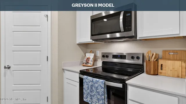 a kitchen with stainless steel appliances white cabinets and a stove