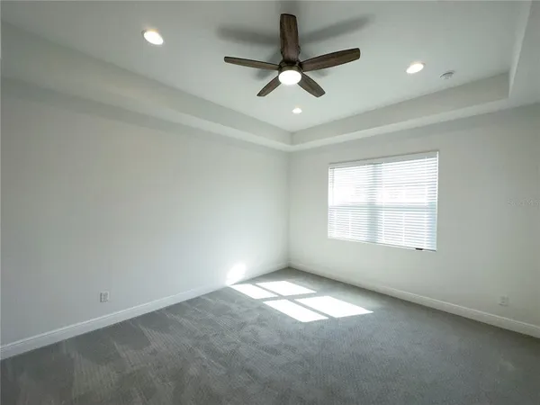 an empty room with a window and a ceiling fan