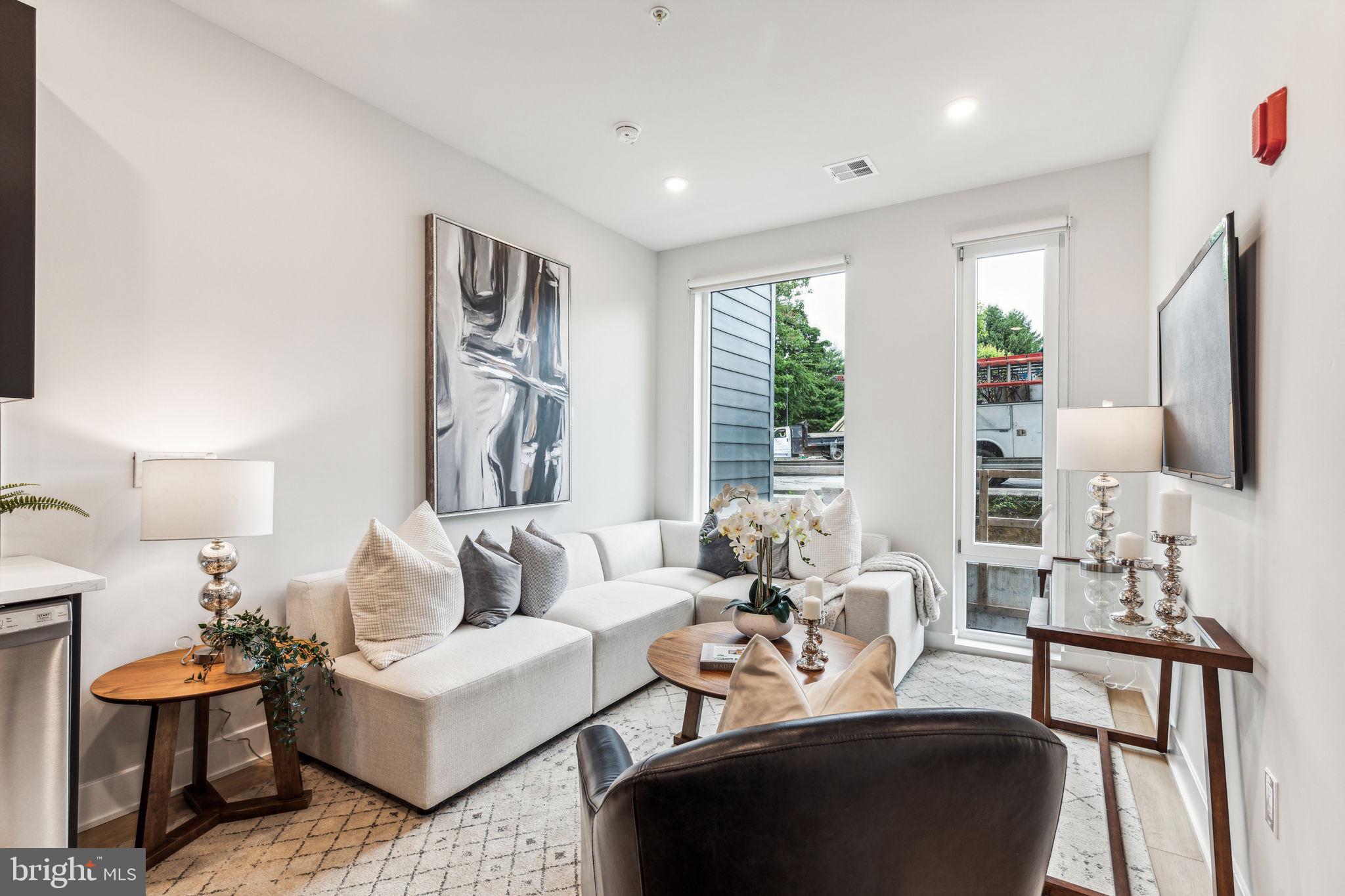 a living room with furniture fireplace and large windows