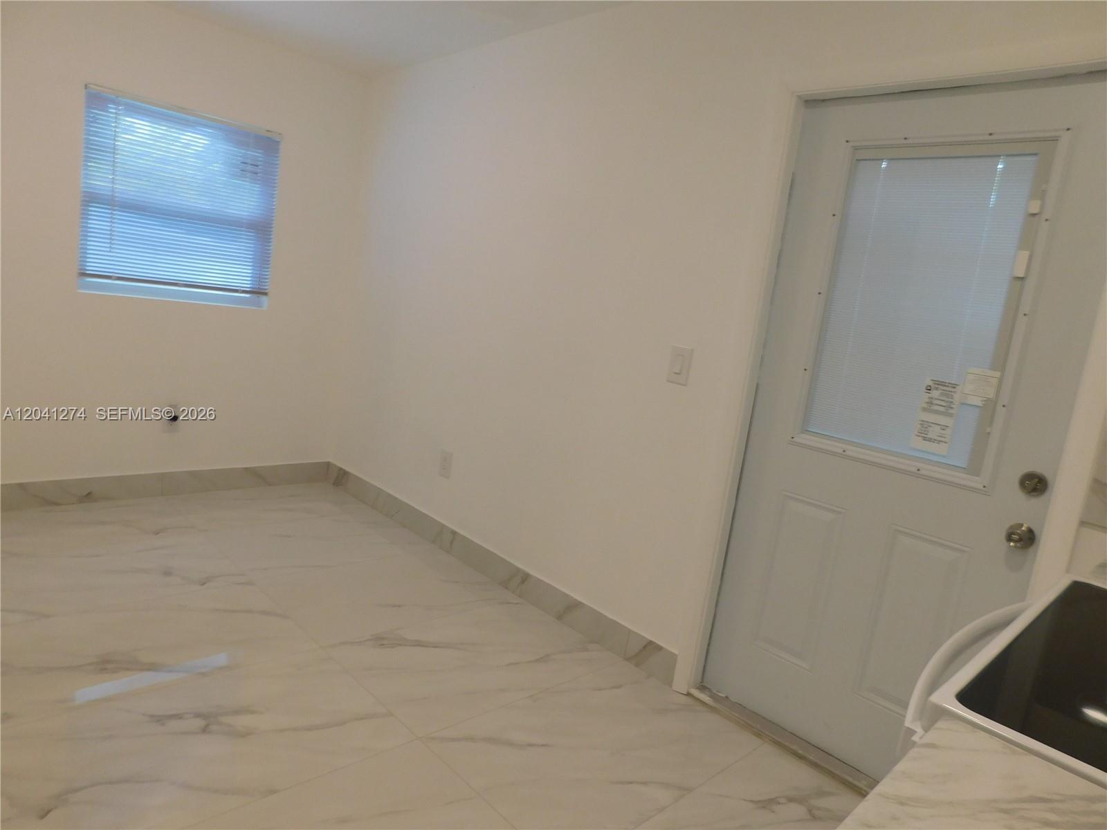 2230 Northwest 58th Street, Unit B Miami, FL 33142 - Photo 11 of 18 an empty room with a bench