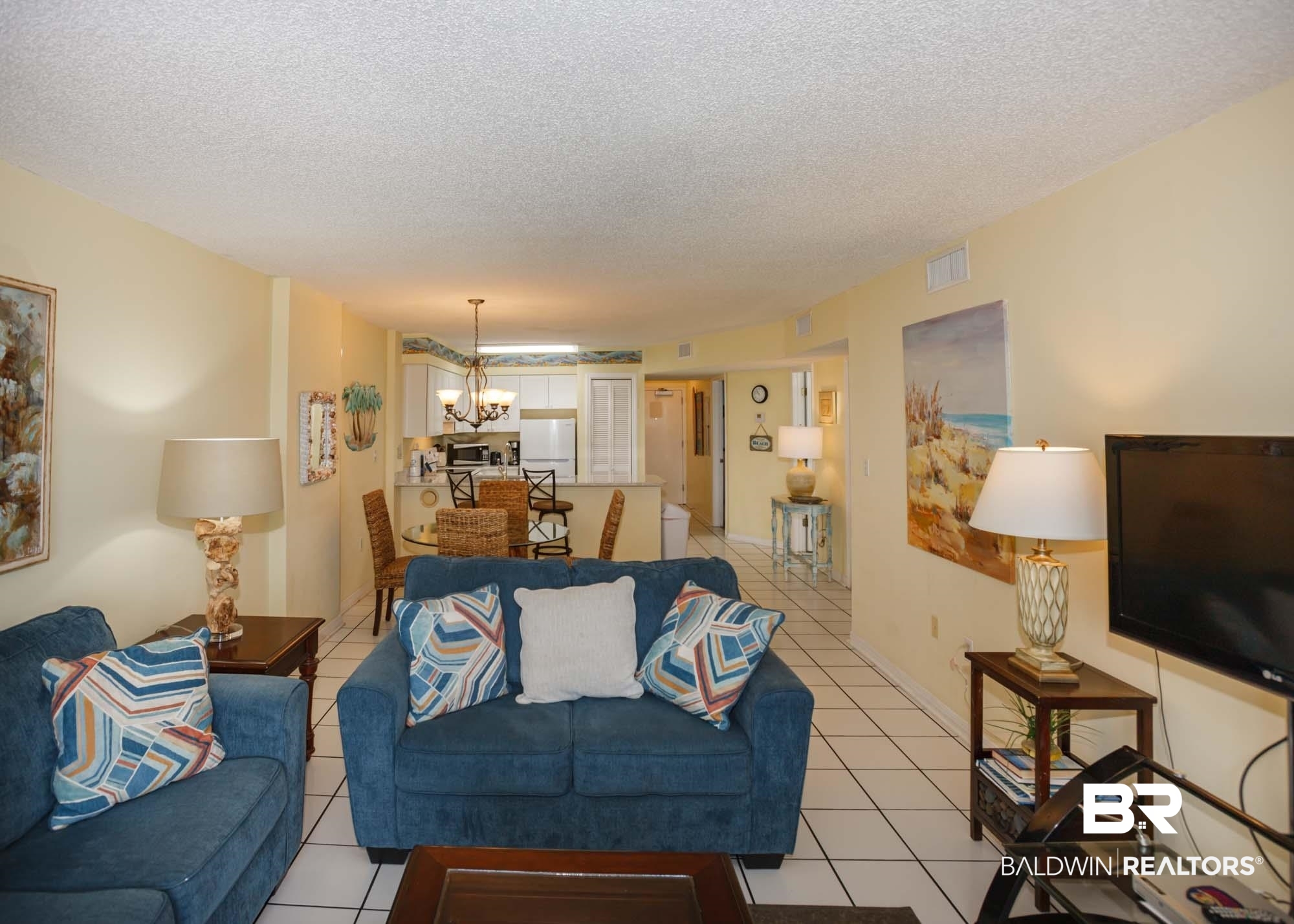 645 Plantation Road, Unit 6311 Gulf Shores, AL 36542 - Photo 31 of 43 Living area with a chandelier, light tile patterned flooring, and a textured ceiling