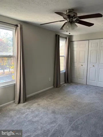 an empty room with windows and cabinet