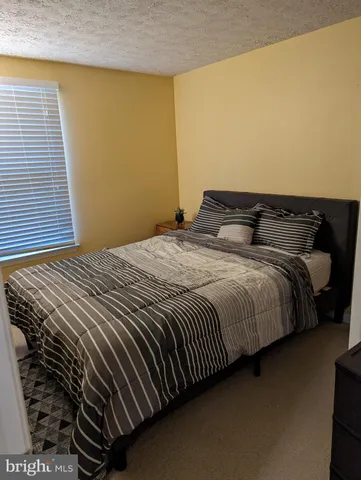 a bedroom with a bed and a night stand