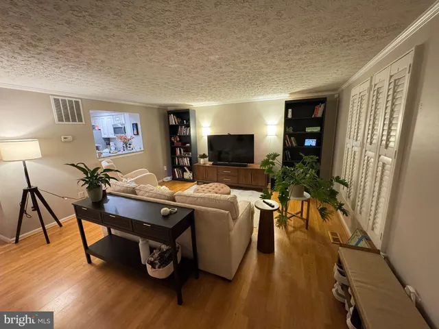 a living room with furniture a flat screen tv and a wooden floor