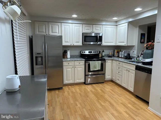 a kitchen with stainless steel appliances a sink a stove a microwave and cabinets